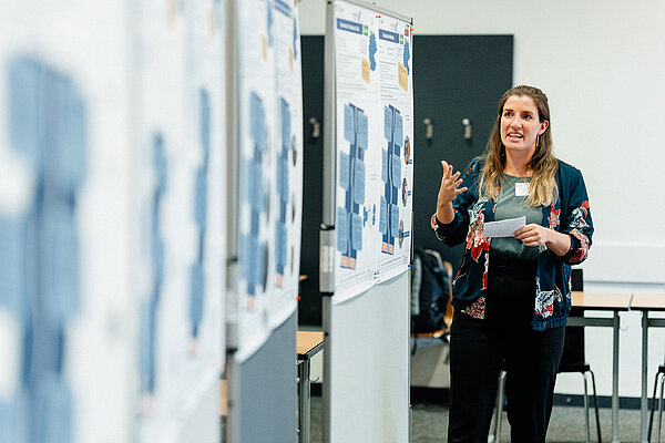 Eine Frau hält einen Vortrag mit Hilfe von Grafiken auf Flipcharts